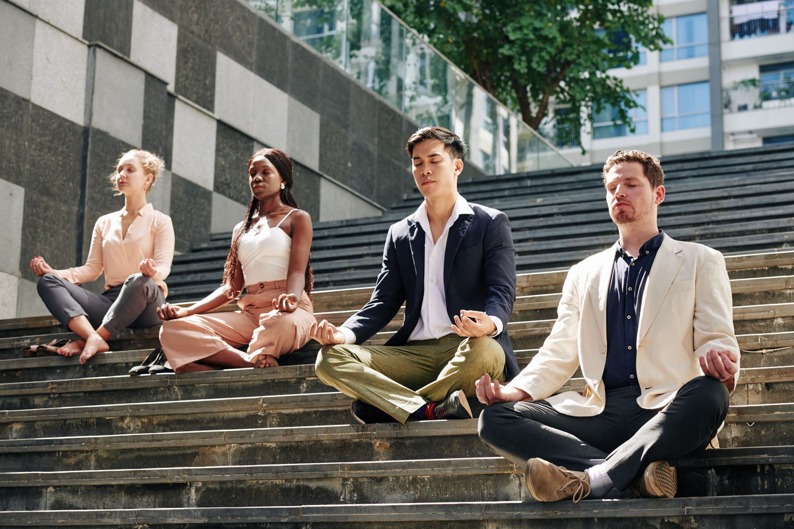 Business people meditating on steps in the street