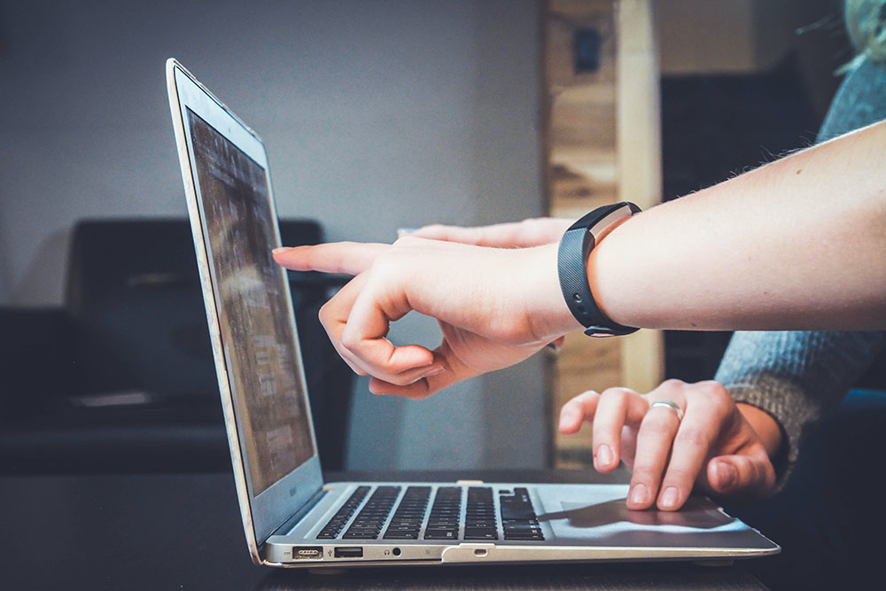 People pointing at a laptop