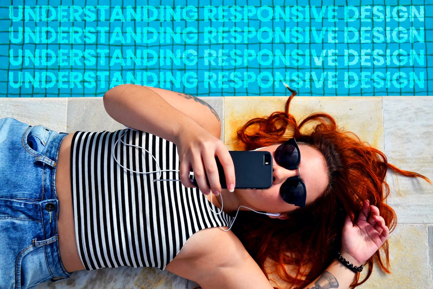 Woman laying next to a pool looking at her mobile phone